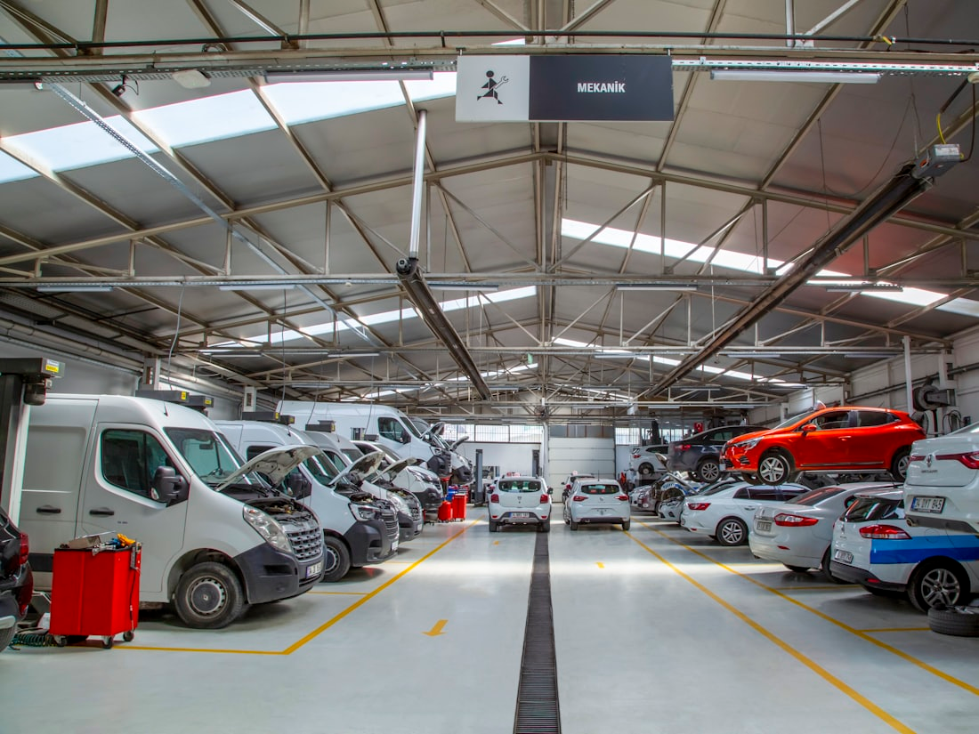 Interior of a vehicle workshop with vans and cars being worked on