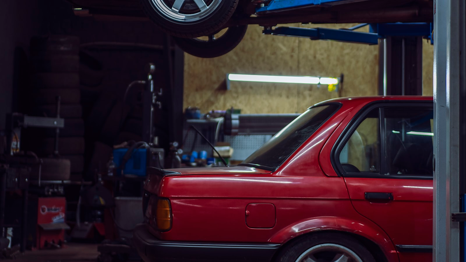 A car raised on a two-post ramp ready for an MOT inspection