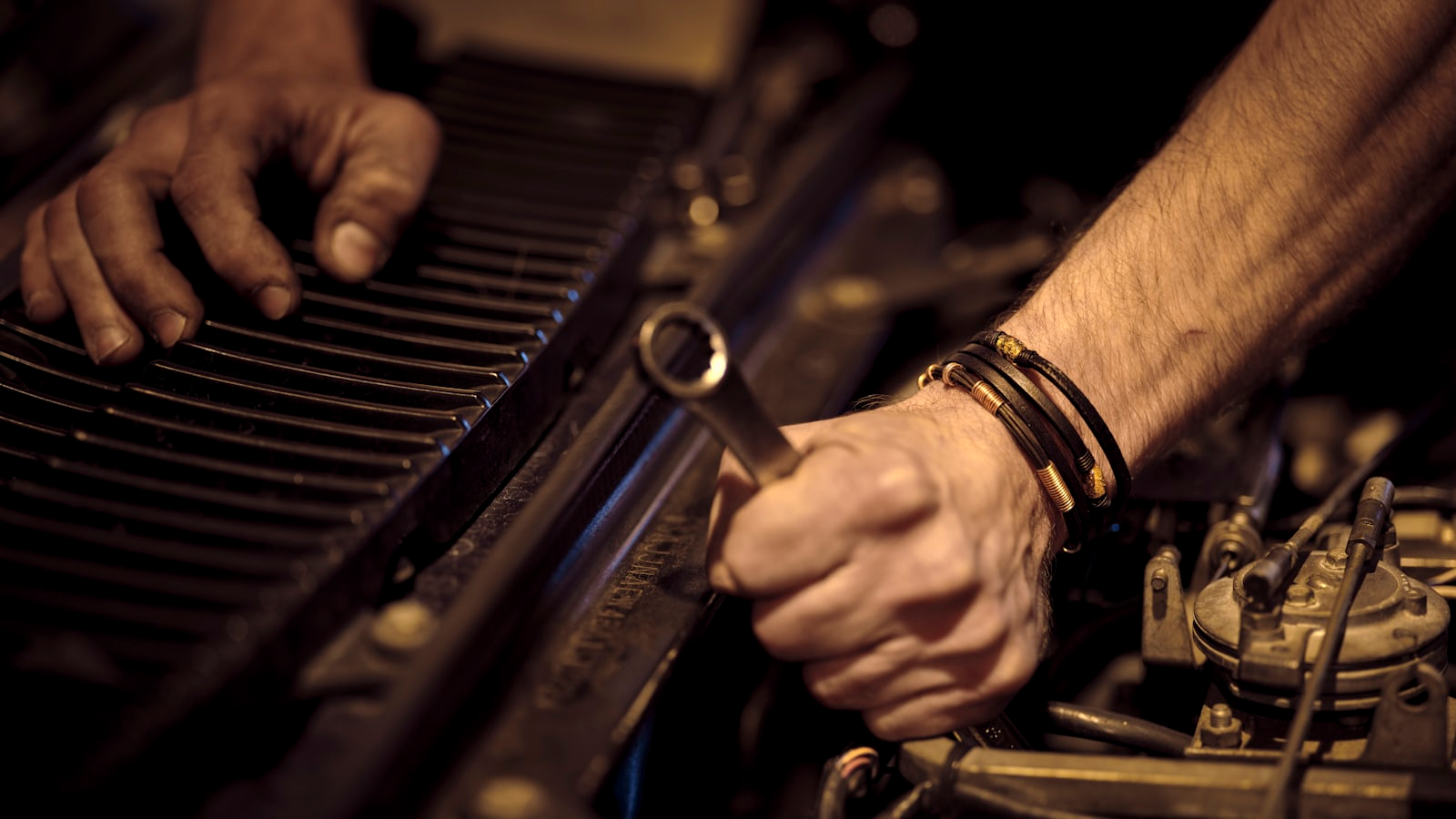 A mechanic using a spanner to repair a car engine
